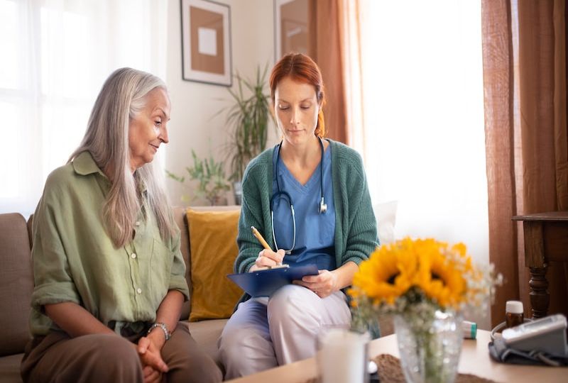 Nurse cosulting with senior her health condition.