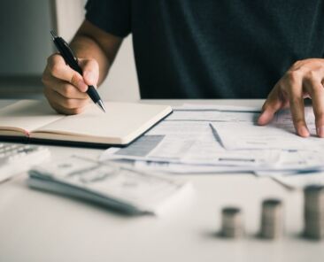 Man use calculators and documents that calculate expenses in the home office.