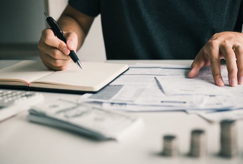 Man use calculators and documents that calculate expenses in the home office.