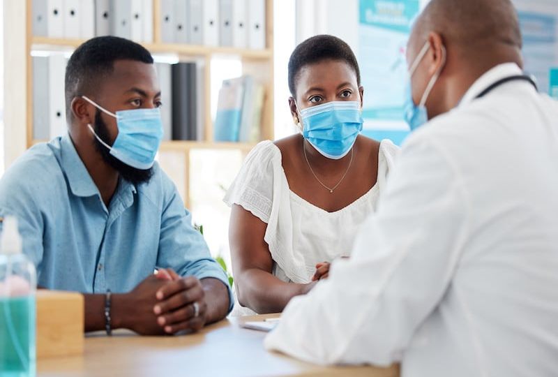 African american married couple in consult for fertility treatment. Medical doctor talking to a cou