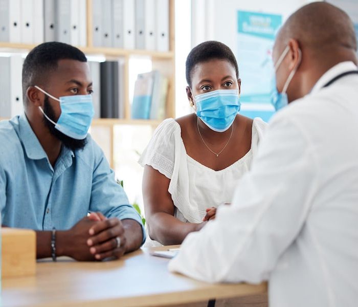 African american married couple in consult for fertility treatment. Medical doctor talking to a cou