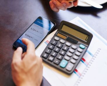 Close-up image of man checking his banking account via mobile application when calculating price of trip