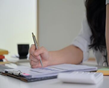 Close - up shot of Hand of business pointing to graphs to examine data.