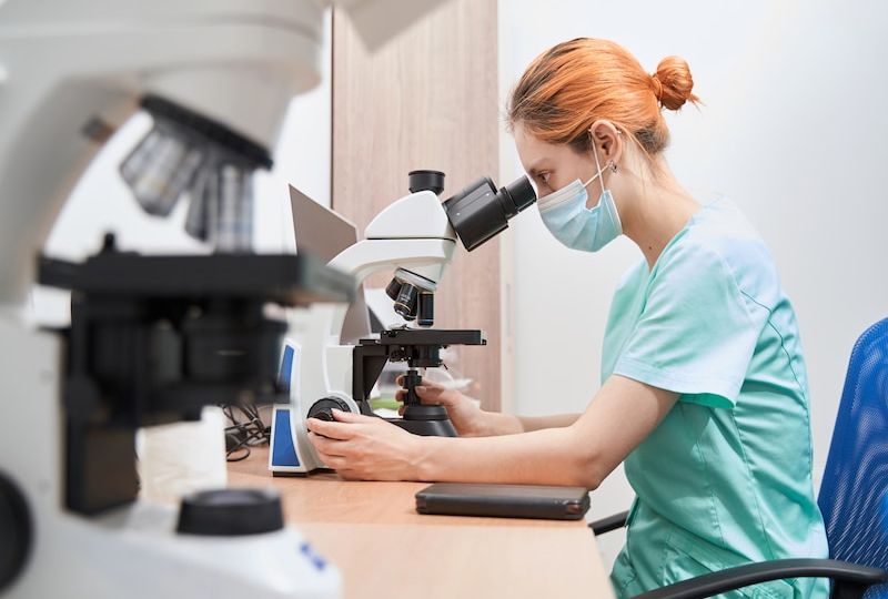 Scientist working in the hospital with microscope