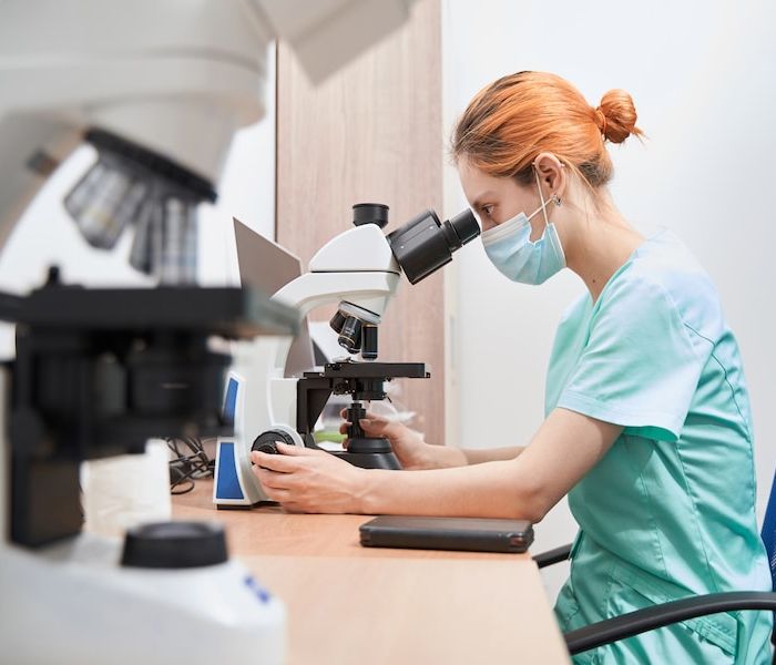 Scientist working in the hospital with microscope