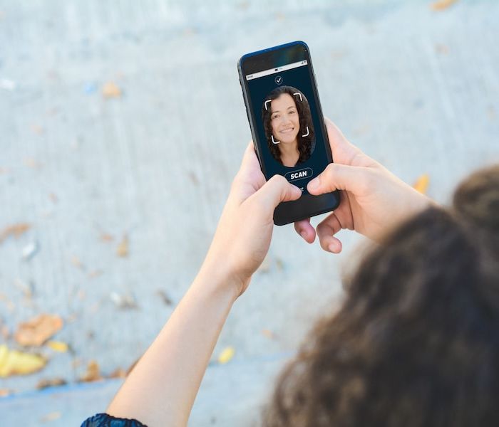 Woman unlocking smartphone with facial recognition technology